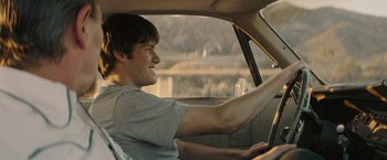Movie still from “The Last Rampage” (2017), directed by Dwight H. Little – A man sitting in the driver's seat of a car; Medium shot, Over the shoulder angle