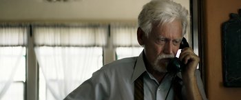 Movie still from “The Last Rampage” (2017), directed by Dwight H. Little – An older man with a white beard is smoking a cigarette; Close Up shot, Low angle