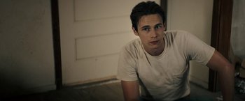 Movie still from “The Last Rampage” (2017), directed by Dwight H. Little – A man sitting on the ground in front of a wall; Close Up shot, Over the shoulder angle