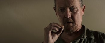 Movie still from “The Last Rampage” (2017), directed by Dwight H. Little – A person smoking a cigarette; Close Up shot, Low angle