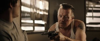 Movie still from “The Last Rampage” (2017), directed by Dwight H. Little – A man holding a gun while wearing a white shirt; Close Up shot, Over the shoulder angle