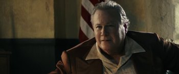 Movie still from “The Last Rampage” (2017), directed by Dwight H. Little – An older man in a brown jacket is looking at the camera; Close Up shot, Over the shoulder angle