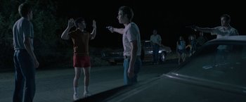 Movie still from “The Last Rampage” (2017), directed by Dwight H. Little – A group of people standing on the side of a road; Medium shot, Over the shoulder angle