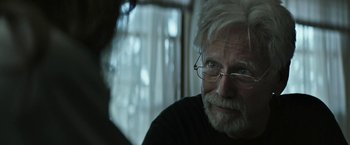 Movie still from “The Last Rampage” (2017), directed by Dwight H. Little – An older man with white hair wearing glasses; Close Up shot, Over the shoulder angle