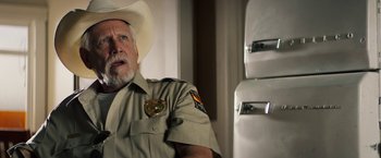 Movie still from “The Last Rampage” (2017), directed by Dwight H. Little – A man wearing a cowboy hat and a uniform; Close Up shot, Over the shoulder angle