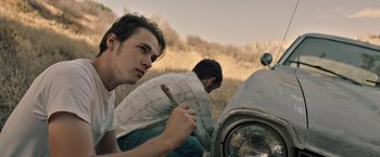 Movie still from “The Last Rampage” (2017), directed by Dwight H. Little – Two men are working on a car that is broken down; Close Up shot, Low angle