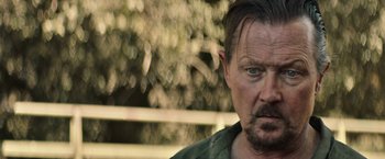 Movie still from “The Last Rampage” (2017), directed by Dwight H. Little – A person wearing a green shirt; Close Up shot, Over the shoulder angle