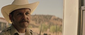 Movie still from “The Last Rampage” (2017), directed by Dwight H. Little – A man with a mustache wearing a cowboy hat; Close Up shot, Over the shoulder angle