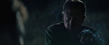 Movie still from “The Last Rampage” (2017), directed by Dwight H. Little – A person wearing a green shirt with smoke coming out; Close Up shot, Over the shoulder angle