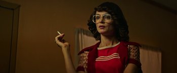 Movie still from “The Last Rampage” (2017), directed by Dwight H. Little – A woman in a red dress smoking a cigarette; Close Up shot, Low angle