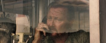 Movie still from “The Last Rampage” (2017), directed by Dwight H. Little – A man talking on a phone while looking out a train window; Close Up shot, Low angle