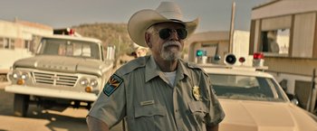 Movie still from “The Last Rampage” (2017), directed by Dwight H. Little – An older man wearing a cowboy hat and sunglasses; Medium shot, Over the shoulder angle