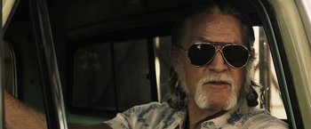 Movie still from “The Last Rampage” (2017), directed by Dwight H. Little – An older man with a beard wearing sunglasses; Close Up shot, Over the shoulder angle