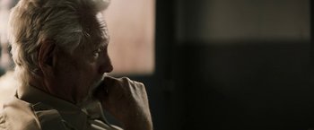 Movie still from “The Last Rampage” (2017), directed by Dwight H. Little – An older man sitting in front of a window with his hand under his chin; Close Up shot, Over the shoulder angle