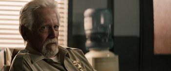 Movie still from “The Last Rampage” (2017), directed by Dwight H. Little – An older man sitting in front of a water cooler; Close Up shot, Over the shoulder angle