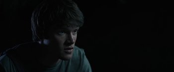 Movie still from “The Last Rampage” (2017), directed by Dwight H. Little – A young man stares into the camera in the dark; Close Up shot, Over the shoulder angle