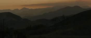 Movie still from “The Last Rampage” (2017), directed by Dwight H. Little – The sun is setting over a mountain range; Extreme Wide shot, High angle