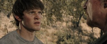 Movie still from “The Last Rampage” (2017), directed by Dwight H. Little – A young man looking to his left while standing next to a tree; Close Up shot, Low angle