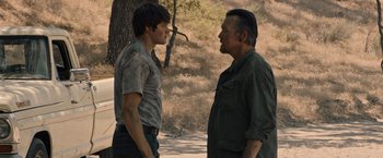 Movie still from “The Last Rampage” (2017), directed by Dwight H. Little – Two men standing next to each other on a dirt road; Medium shot, Over the shoulder angle