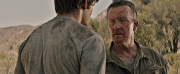 Movie still from “The Last Rampage” (2017), directed by Dwight H. Little – Two men standing next to each other on a field; Close Up shot, Over the shoulder angle