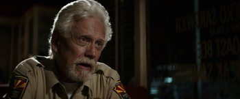 Movie still from “The Last Rampage” (2017), directed by Dwight H. Little – An older man with white hair and a white beard; Close Up shot, Over the shoulder angle