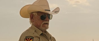 Movie still from “The Last Rampage” (2017), directed by Dwight H. Little – An older man wearing a cowboy hat and sun glasses; Close Up shot, Over the shoulder angle