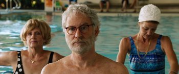 Movie still from “Last Vegas” (2013), directed by Jon Turteltaub – An older man with white hair and glasses in front of a swimming pool; Close Up shot, Over the shoulder angle