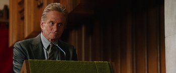 Movie still from “Last Vegas” (2013), directed by Jon Turteltaub – A man in a suit and tie is standing at a podium; Close Up shot, Low angle