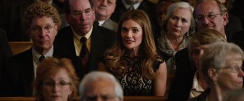 Movie still from “Last Vegas” (2013), directed by Jon Turteltaub – A woman in a black and white dress sitting in front of a group of people; Close Up shot, Over the shoulder angle