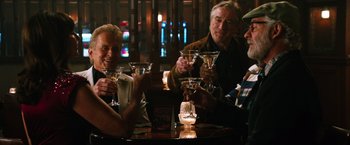 Movie still from “Last Vegas” (2013), directed by Jon Turteltaub – A group of people sitting at a table holding martini glasses; Medium shot, High angle