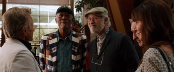 Movie still from “Last Vegas” (2013), directed by Jon Turteltaub – Two men standing next to each other in front of a plant; Medium shot, Low angle