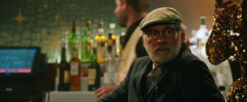 Movie still from “Last Vegas” (2013), directed by Jon Turteltaub – An older man wearing glasses and a hat is sitting at a bar; Close Up shot, Over the shoulder angle