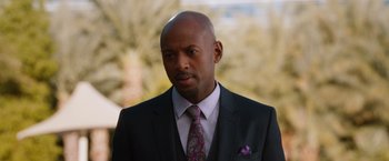 Movie still from “Last Vegas” (2013), directed by Jon Turteltaub – A man in a suit and tie standing in front of trees; Close Up shot, Over the shoulder angle