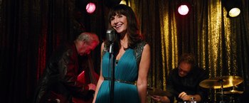 Movie still from “Last Vegas” (2013), directed by Jon Turteltaub – A woman in a blue dress singing into a microphone; Medium shot, Over the shoulder angle