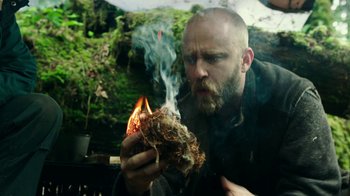 Movie still from “Leave No Trace” (2018), directed by Debra Granik – A man with a beard is holding a fire in his mouth; Close Up shot, Low angle