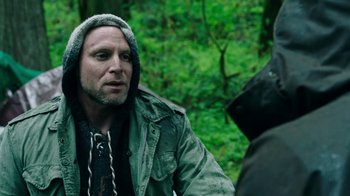 Movie still from “Leave No Trace” (2018), directed by Debra Granik – A man wearing a hood talking to another man in the woods; Close Up shot, Over the shoulder angle