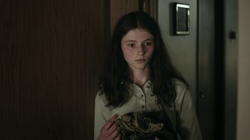 Movie still from “Leave No Trace” (2018), directed by Debra Granik – A young girl is holding a stuffed animal in her hands; Close Up shot, Over the shoulder angle