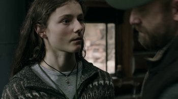 Movie still from “Leave No Trace” (2018), directed by Debra Granik – A young woman wearing a sweater and a necklace; Close Up shot, Over the shoulder angle