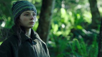 Movie still from “Leave No Trace” (2018), directed by Debra Granik – A young woman wearing a hat in the woods; Close Up shot, Low angle