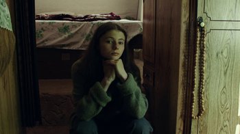 Movie still from “Leave No Trace” (2018), directed by Debra Granik – A girl sitting on the floor of a bedroom; Medium shot, High angle