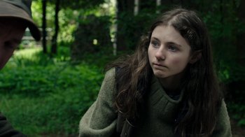 Movie still from “Leave No Trace” (2018), directed by Debra Granik – A young girl in a wooded area looking to her left; Close Up shot, Over the shoulder angle