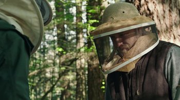 Movie still from “Leave No Trace” (2018), directed by Debra Granik – A man wearing a bee suit in the woods; Close Up shot, Over the shoulder angle