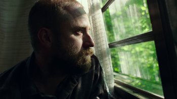 Movie still from “Leave No Trace” (2018), directed by Debra Granik – A man with a beard looking out of a window; Close Up shot, Low angle
