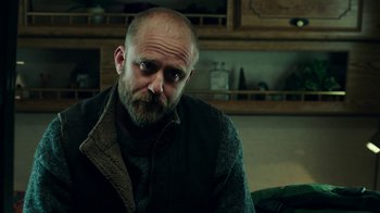 Movie still from “Leave No Trace” (2018), directed by Debra Granik – A man sitting in a chair with his nose up; Close Up shot, Low angle