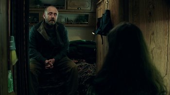 Movie still from “Leave No Trace” (2018), directed by Debra Granik – A man sitting on the floor in front of another man; Medium shot, Over the shoulder angle