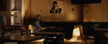 A man sitting at a table in front of a mural