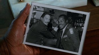 Movie still from “Lethal Weapon” (1987), directed by Richard Donner – A person holding a picture of two soldiers; Close Up shot, Overhead angle