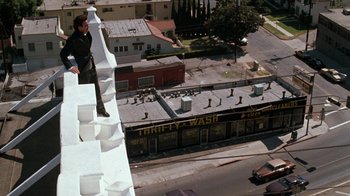 Movie still from “Lethal Weapon” (1987), directed by Richard Donner – A man standing on the side of a building looking down; Extreme Wide shot, High angle