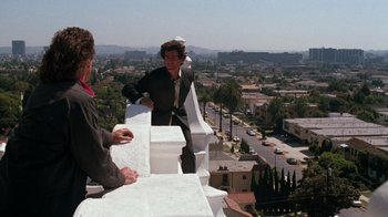 Movie still from “Lethal Weapon” (1987), directed by Richard Donner – Two people standing on a building on a roof top; Wide shot, High angle