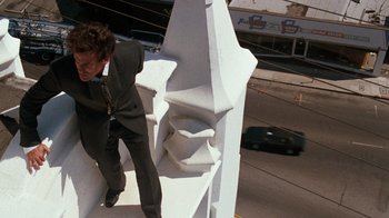 Movie still from “Lethal Weapon” (1987), directed by Richard Donner – A man standing on top of a white building; Wide shot, Low angle